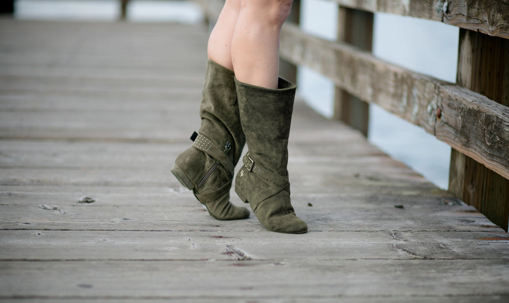 Aurora dance boots dark/olive green pair folded up in action, on wooden dock background
